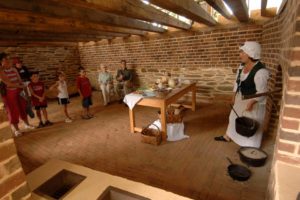 A small group of visitors listen to a guide in the kitchen at Poplar Forest, Thomas Jefferson's retreat home.