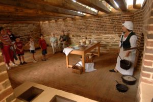 A small group of visitors listen to a guide in the kitchen at Poplar Forest, Thomas Jefferson's retreat home.