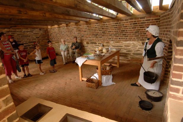 A small group of visitors listen to a guide in the kitchen at Poplar Forest, Thomas Jefferson's retreat home.
